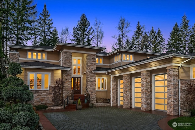 back house at dusk featuring a garage