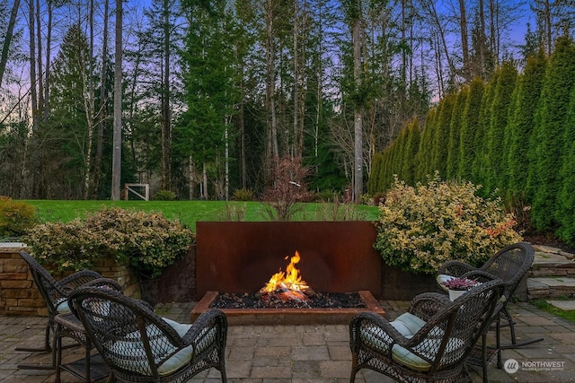 patio terrace at dusk with an outdoor stone fireplace