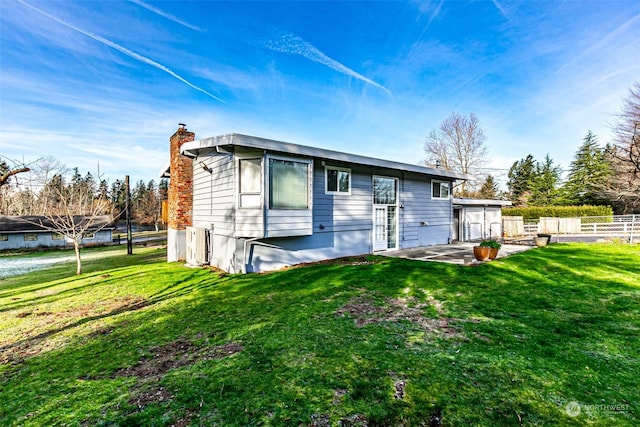 rear view of house featuring a patio and a lawn