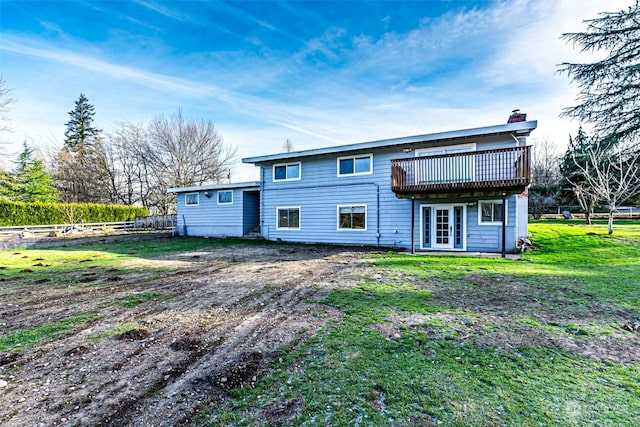 rear view of property with a deck and a yard