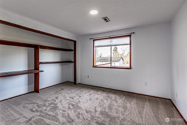 unfurnished bedroom featuring a closet and light colored carpet