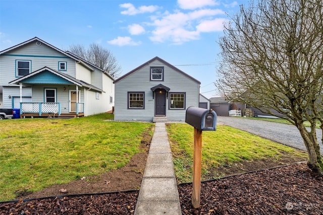 bungalow with a front yard, covered porch, and driveway