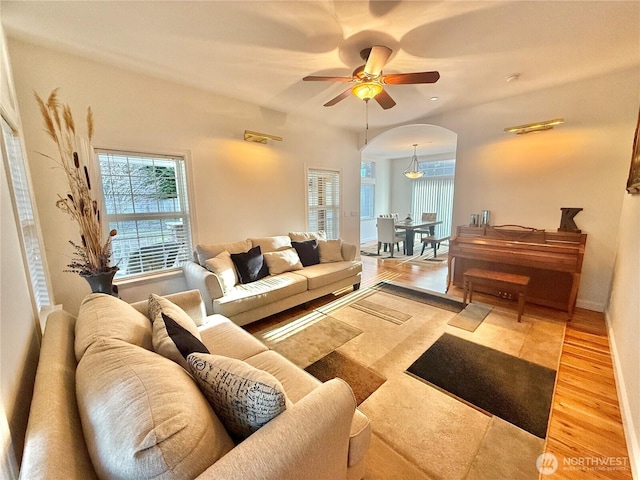 living room with arched walkways, ceiling fan, and wood finished floors