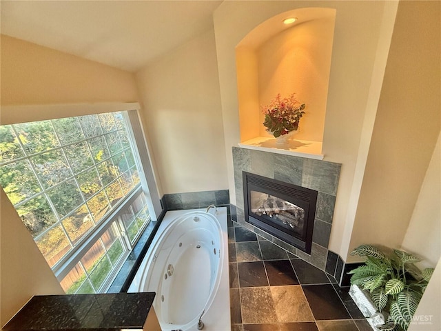 interior space featuring a tub with jets and a tile fireplace