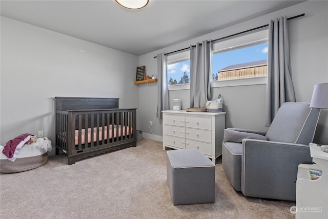 bedroom with a nursery area and carpet flooring