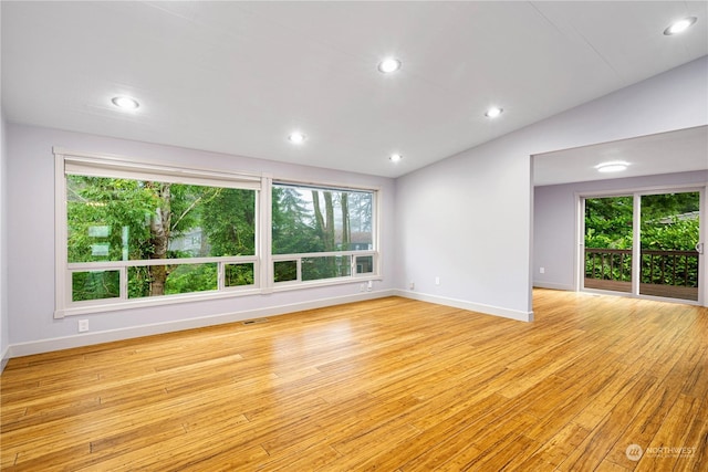 unfurnished living room featuring light hardwood / wood-style flooring, plenty of natural light, and lofted ceiling