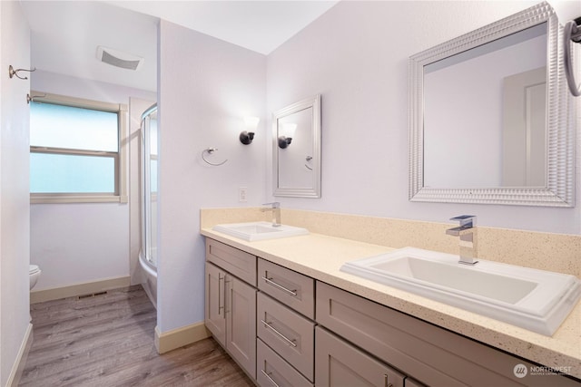 bathroom with vanity, toilet, and hardwood / wood-style flooring