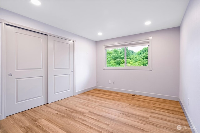 unfurnished bedroom featuring a closet and light wood-type flooring