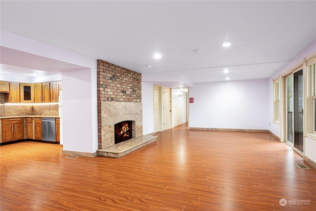 unfurnished living room featuring a large fireplace and light wood-type flooring