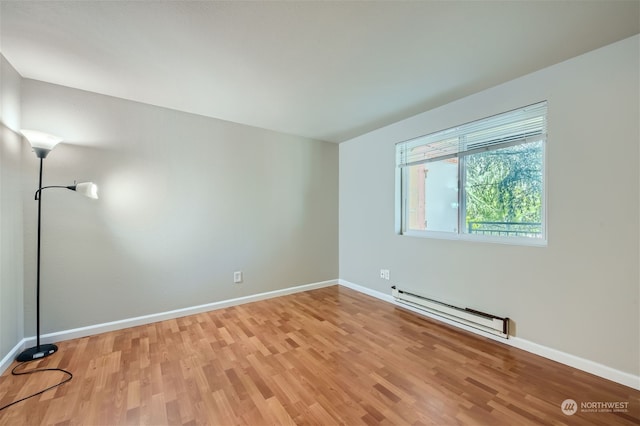 spare room with light wood-type flooring and a baseboard radiator