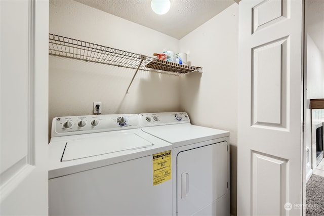 clothes washing area featuring a textured ceiling and separate washer and dryer