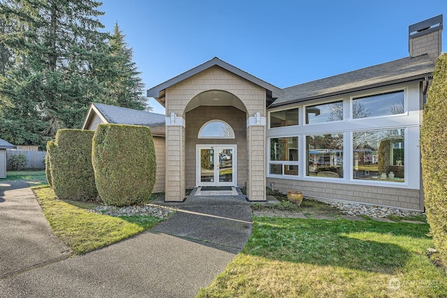 doorway to property with french doors and a lawn