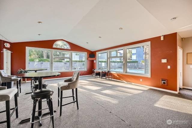 dining area featuring plenty of natural light, carpet, and lofted ceiling