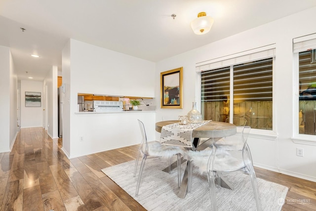 dining space with wood-type flooring