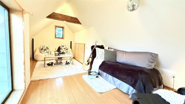 bedroom featuring hardwood / wood-style flooring and lofted ceiling with beams