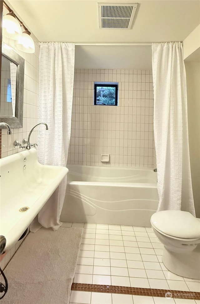 bathroom featuring toilet, shower / bath combination with curtain, and tile patterned floors