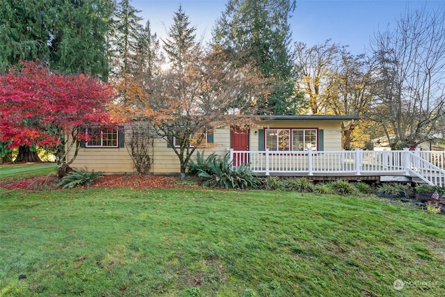 view of front facade with a deck and a front lawn