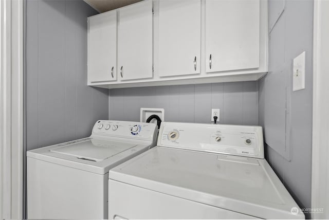 washroom featuring cabinets and washer and clothes dryer