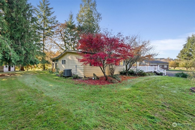 view of side of property with cooling unit and a lawn