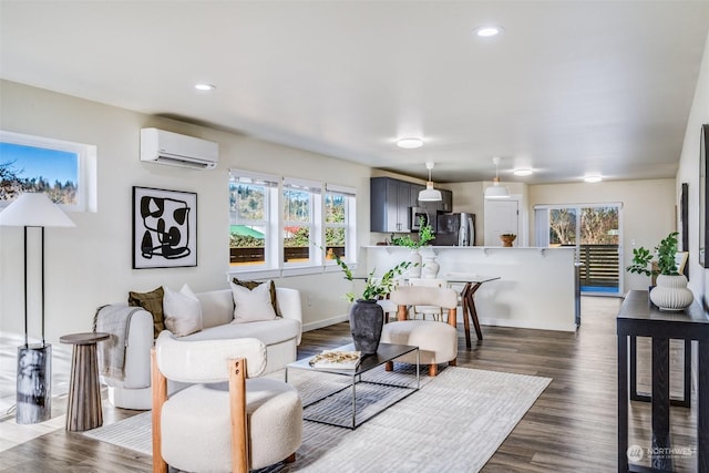 living room with dark wood-type flooring, an AC wall unit, and a wealth of natural light