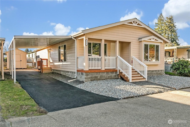 view of front facade featuring a porch, a storage shed, and a carport