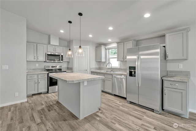 kitchen featuring stainless steel appliances, a kitchen island, pendant lighting, and lofted ceiling