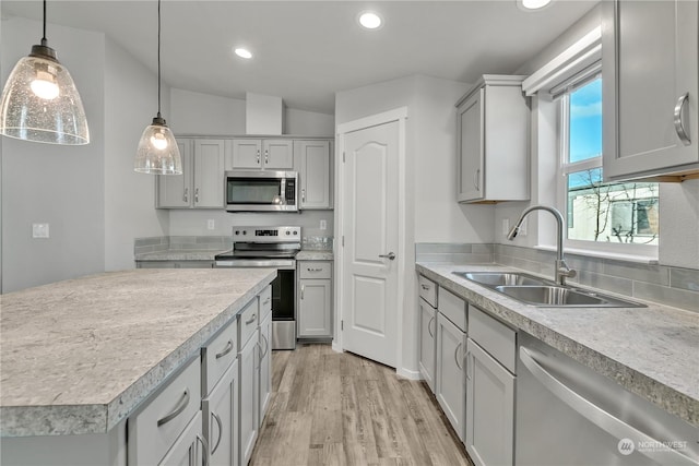 kitchen featuring sink, pendant lighting, gray cabinets, and stainless steel appliances