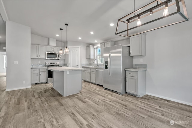 kitchen with gray cabinets, a center island, pendant lighting, and appliances with stainless steel finishes