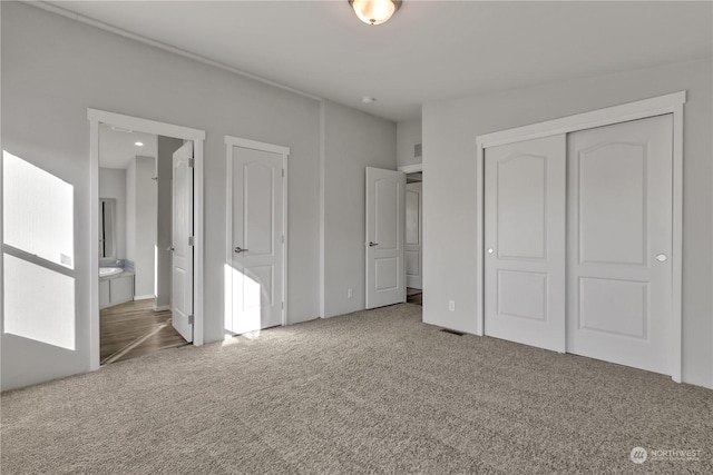 unfurnished bedroom with carpet flooring and ensuite bath