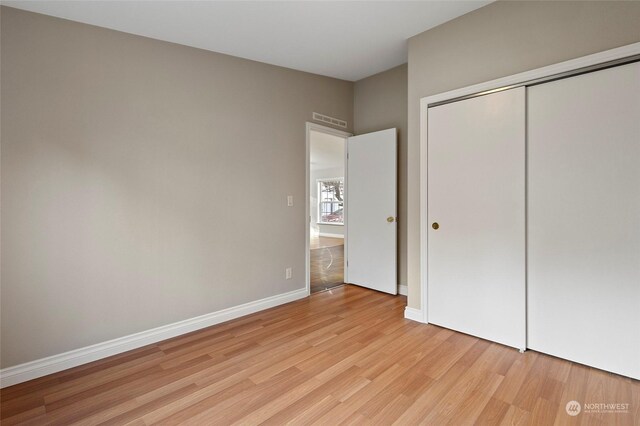 unfurnished bedroom with light hardwood / wood-style floors and a closet