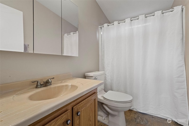 bathroom with vanity, toilet, and vaulted ceiling