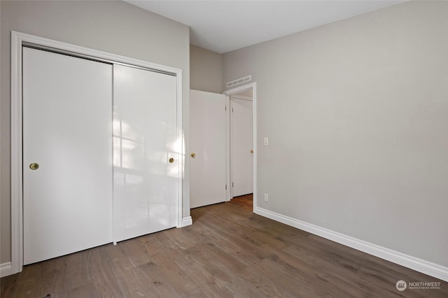 unfurnished bedroom featuring hardwood / wood-style floors and a closet