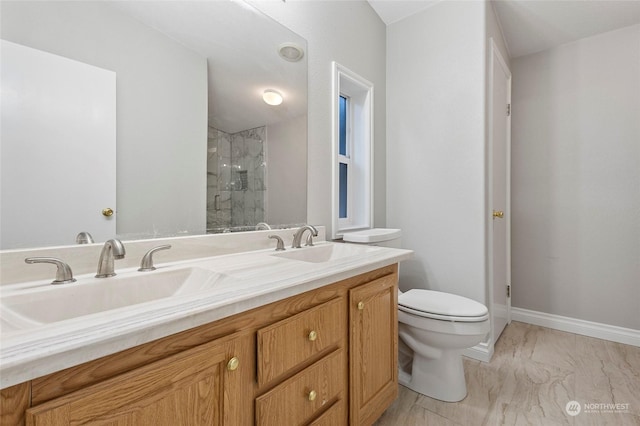 bathroom with a shower with door, vanity, and toilet