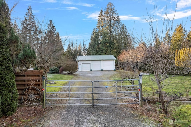 view of gate with an outbuilding and a yard