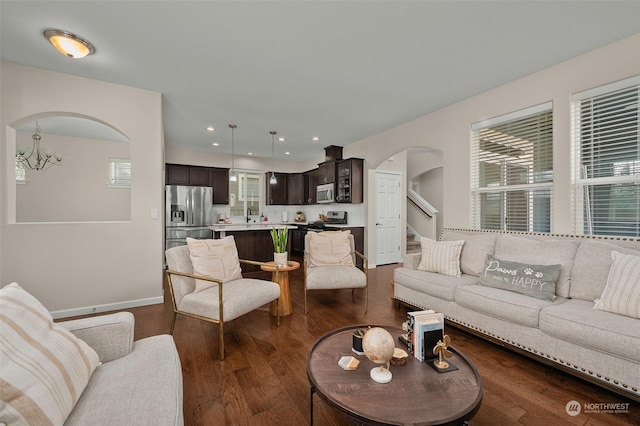 living room featuring an inviting chandelier and dark hardwood / wood-style floors