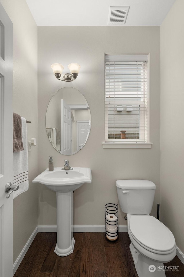 bathroom with hardwood / wood-style flooring and toilet