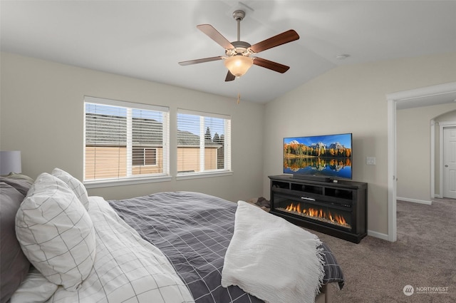 bedroom featuring dark carpet, multiple windows, vaulted ceiling, and ceiling fan