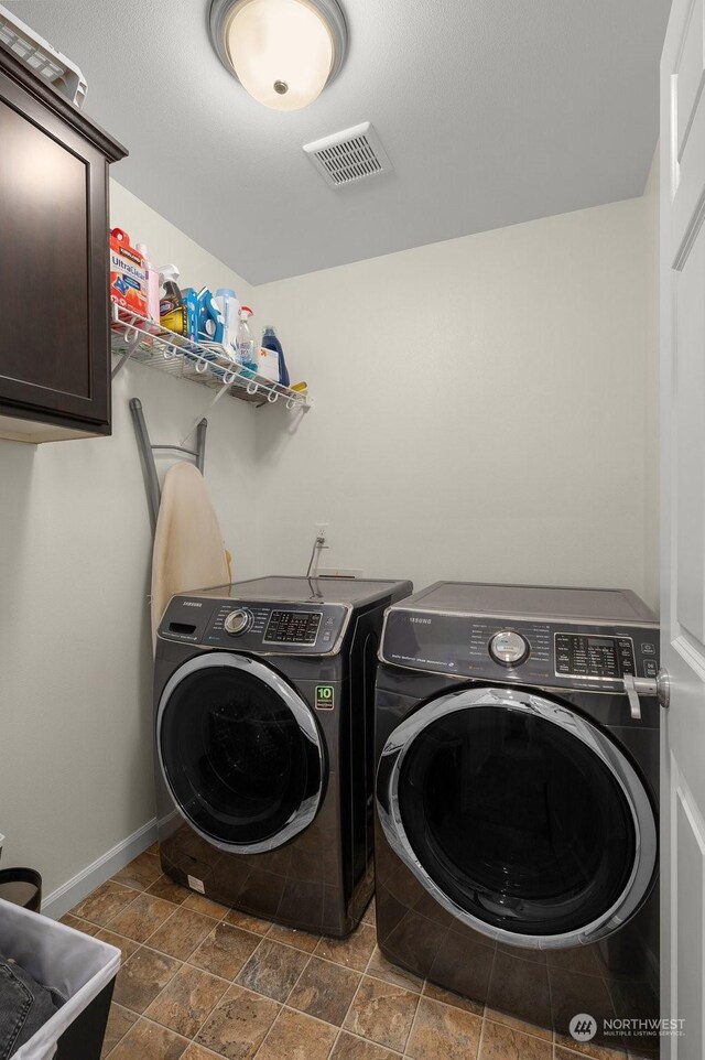 laundry area featuring cabinets and washer and clothes dryer