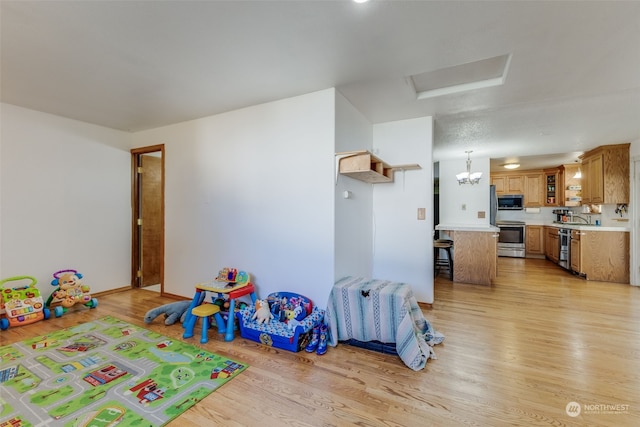 game room with sink and light hardwood / wood-style flooring