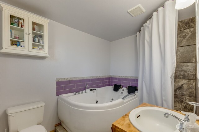 bathroom featuring a tub to relax in, toilet, and sink