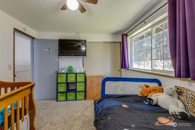 bedroom featuring carpet flooring, a textured ceiling, ceiling fan, and a closet