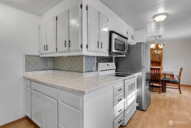 kitchen featuring white cabinetry, backsplash, stainless steel appliances, and light hardwood / wood-style floors