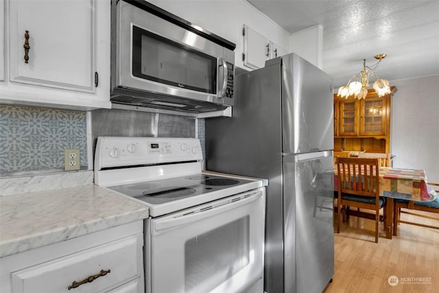 kitchen featuring tasteful backsplash, white cabinetry, light hardwood / wood-style flooring, and electric stove