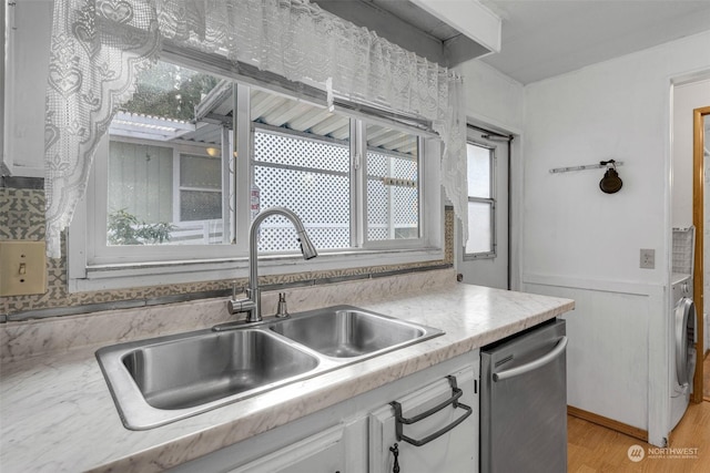 kitchen with white cabinetry, dishwasher, sink, backsplash, and light hardwood / wood-style flooring