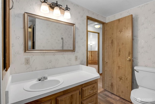 bathroom with wood-type flooring, toilet, and vanity