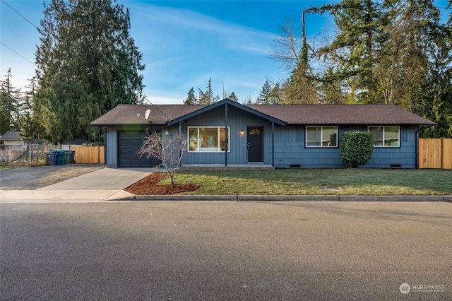 ranch-style house featuring a garage and a front lawn