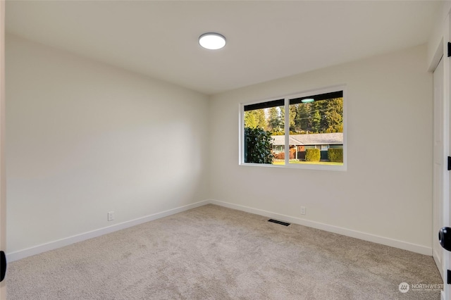 spare room featuring light colored carpet