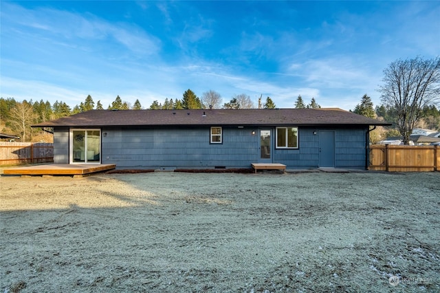 back of house featuring a lawn and a deck