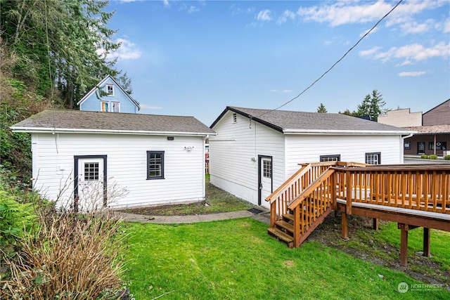 back of property featuring a deck and a yard