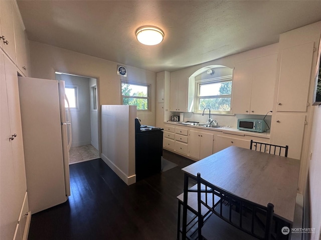 kitchen featuring dark hardwood / wood-style floors, sink, white cabinets, and white refrigerator